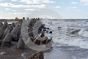 Waves crashing against breakwater consisting of gray concrete tetrapods. Liepaja, Latvia. Liepajas Ziemelu mols